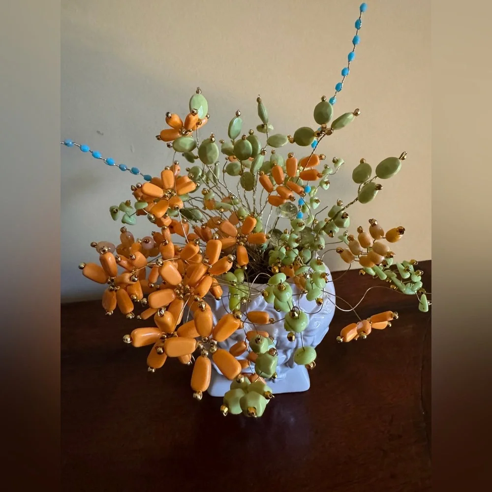 Artificial beaded flowers in white vintage vase